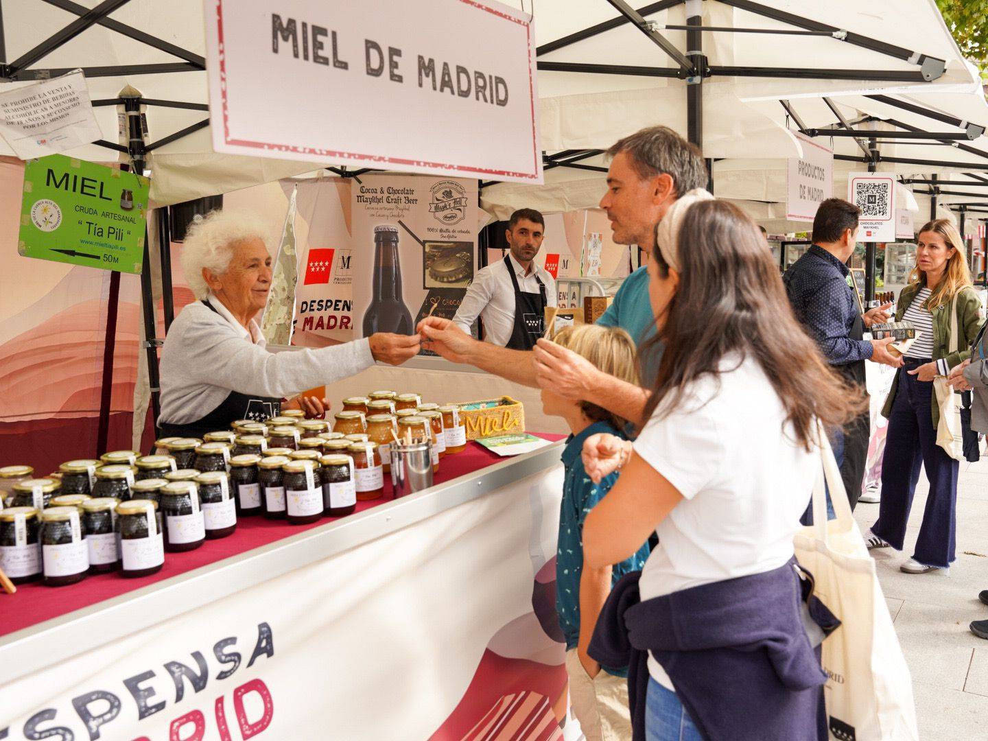 Familia degustando miel en uno de los puestos de La Despensa de Madrid.