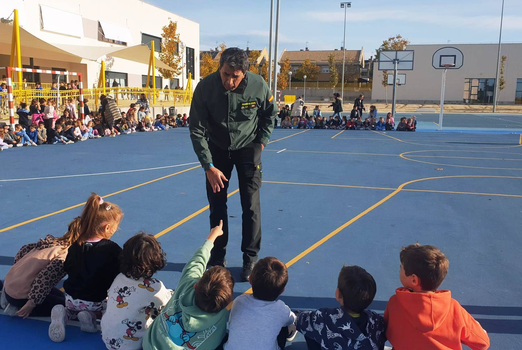 Niños hablando con un miembro de la Guardia Civil.