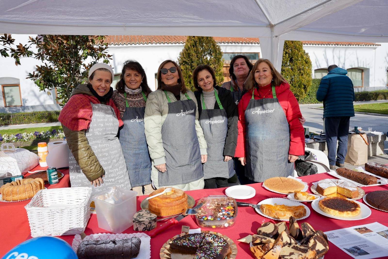 Voluntarias posando en uno de los puestos de venta de dulces.