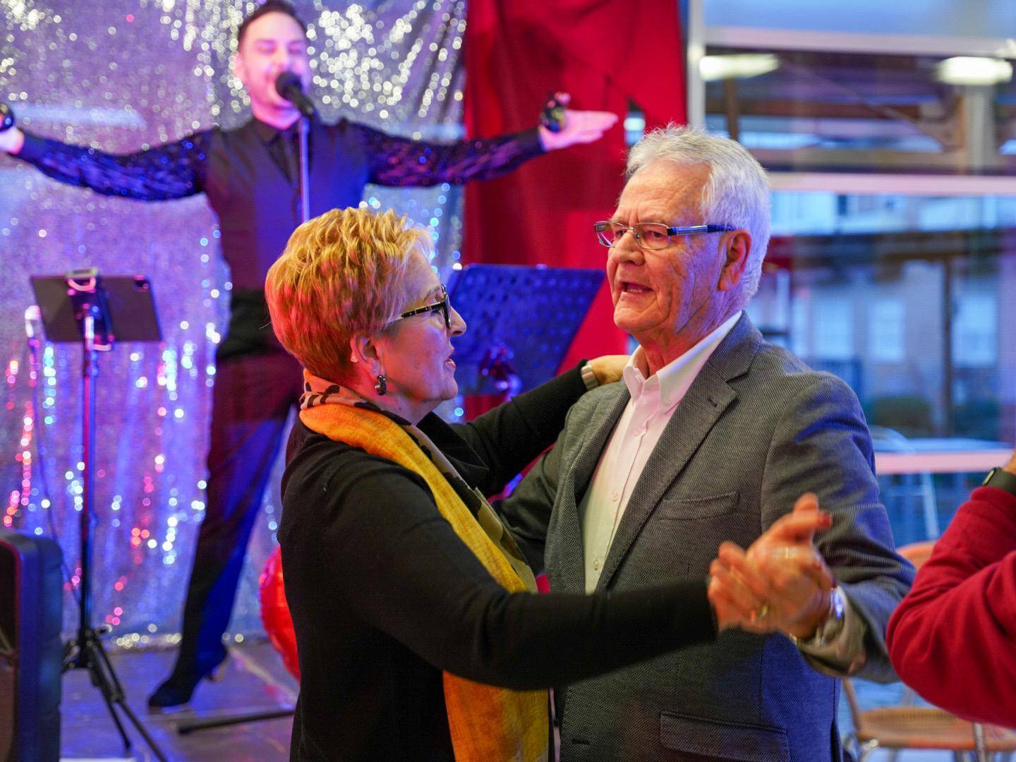 Pareja de mayores bailando ante el cantante.